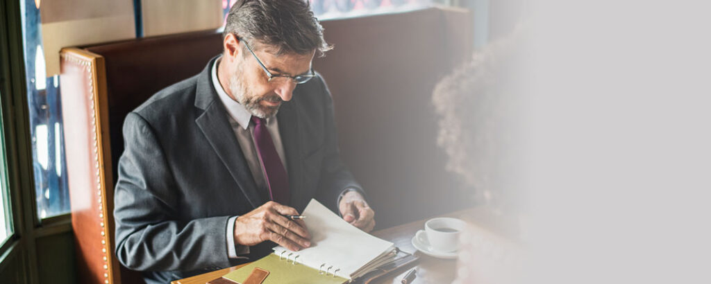 Hombre tomando un café mientras revisa su agenda